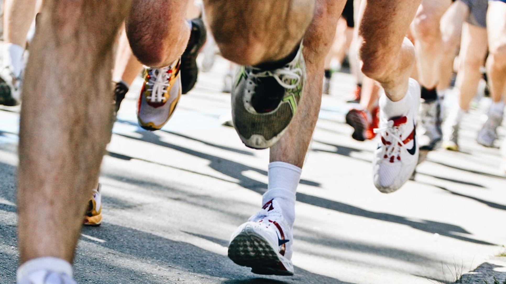 Massor av ben springer på asfalt under ett maraton